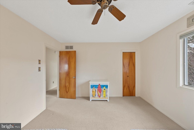 carpeted empty room featuring visible vents and baseboards