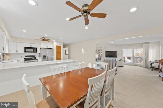 dining room with recessed lighting and light colored carpet