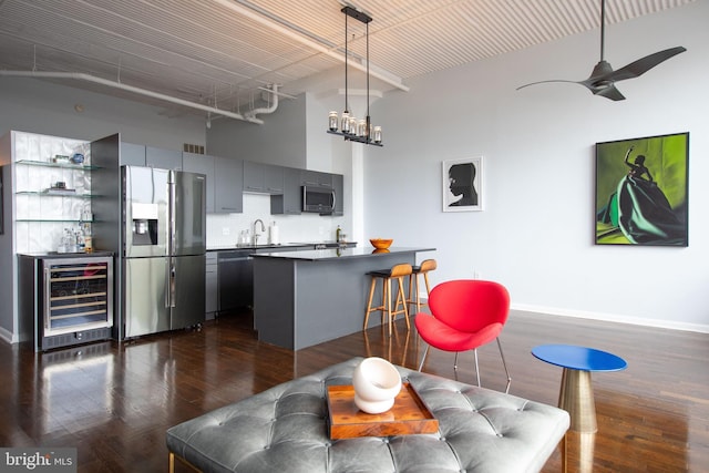 interior space featuring sink, dark hardwood / wood-style flooring, a towering ceiling, ceiling fan, and beverage cooler