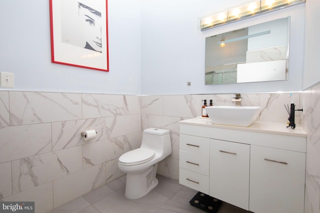 bathroom with vanity, tile walls, and toilet