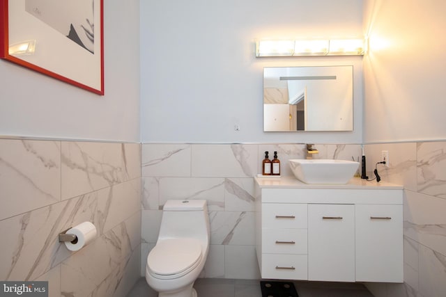 bathroom with vanity, tile walls, and toilet