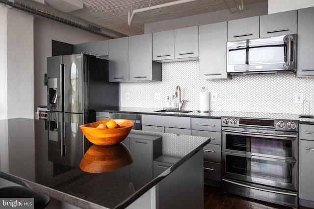 kitchen featuring gray cabinets, appliances with stainless steel finishes, sink, and backsplash