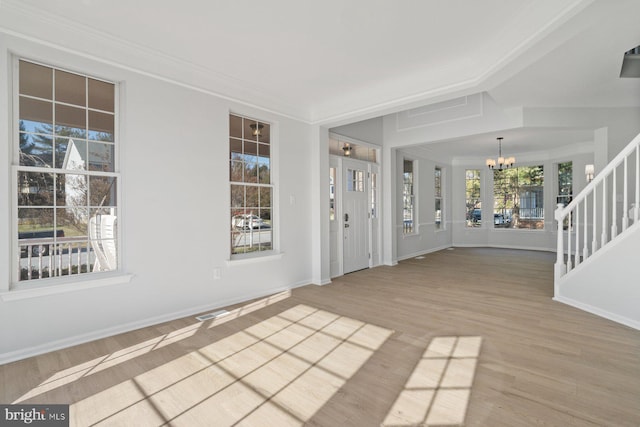 entryway with light hardwood / wood-style flooring, a chandelier, and crown molding