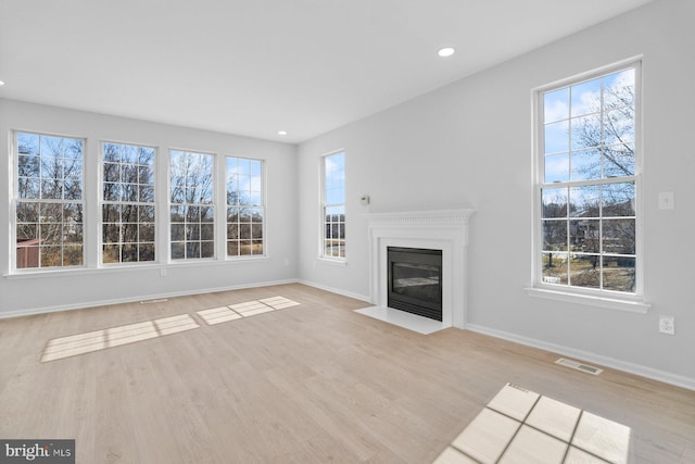 unfurnished living room featuring light hardwood / wood-style floors and a wealth of natural light