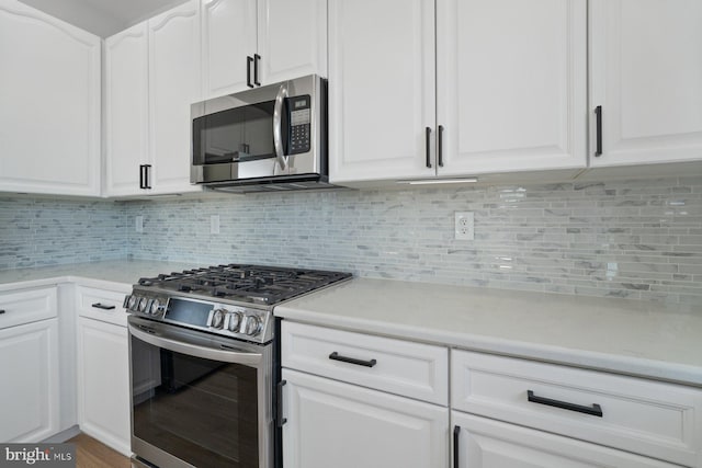 kitchen with appliances with stainless steel finishes, white cabinetry, and decorative backsplash