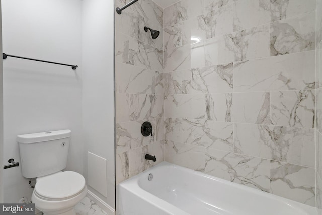 bathroom with tiled shower / bath combo and toilet