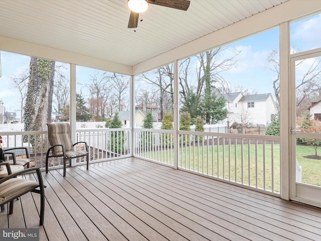 unfurnished sunroom with ceiling fan