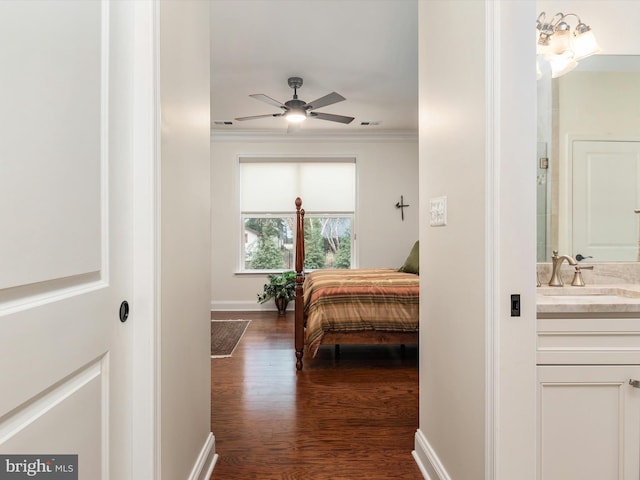 bedroom with ornamental molding, dark hardwood / wood-style flooring, and sink