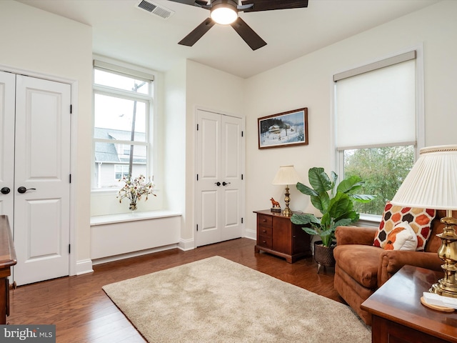 sitting room with ceiling fan and dark hardwood / wood-style flooring