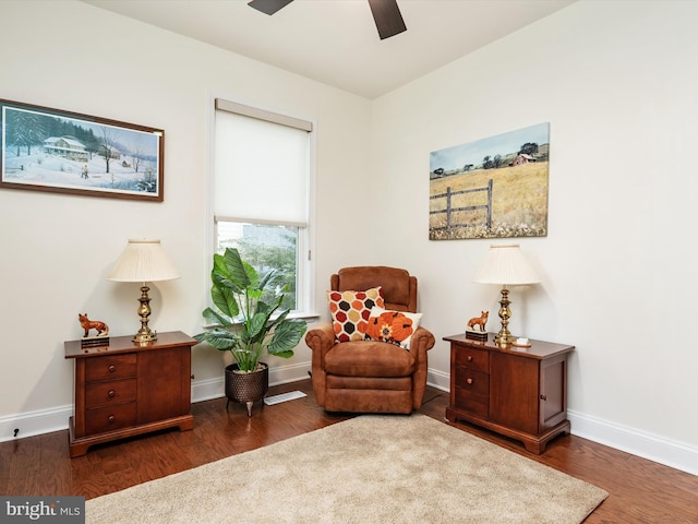 living area with ceiling fan and dark hardwood / wood-style flooring