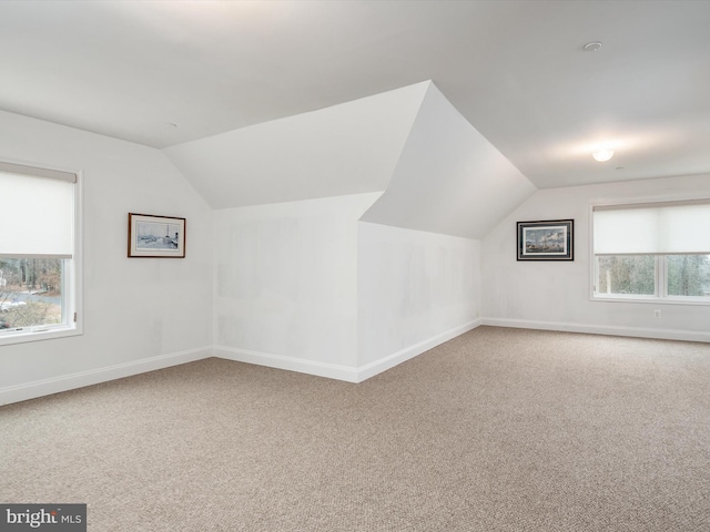 bonus room with lofted ceiling and carpet floors