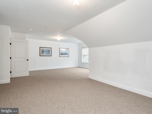 bonus room featuring vaulted ceiling and carpet