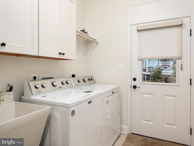 laundry room featuring separate washer and dryer, sink, and cabinets