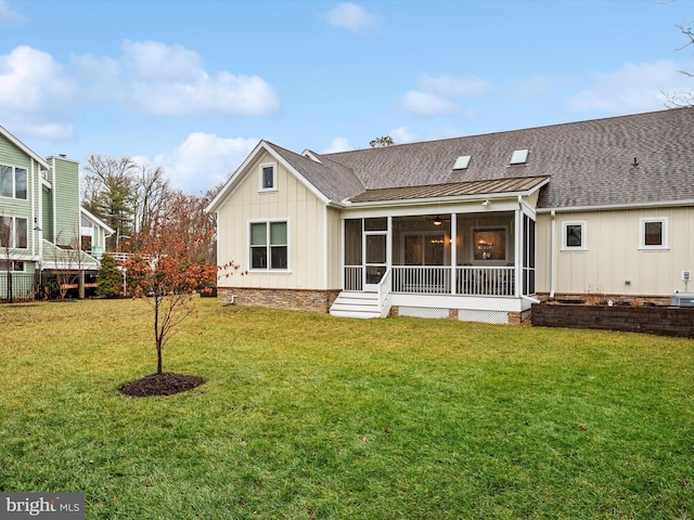 back of property with a sunroom and a yard