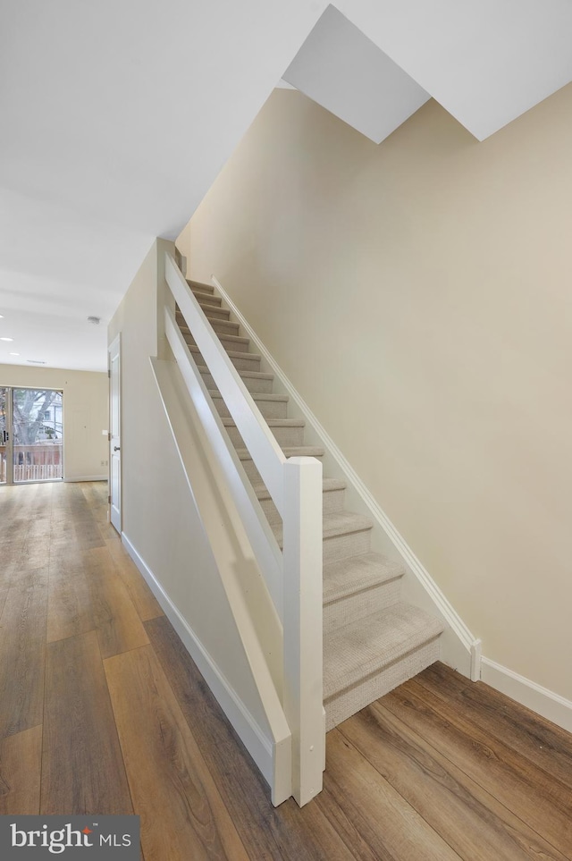 stairway with hardwood / wood-style floors