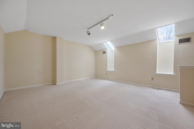 interior space featuring track lighting and light colored carpet