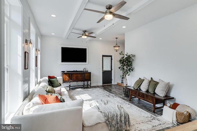 living area featuring recessed lighting, wood finished floors, baseboards, a wealth of natural light, and beamed ceiling