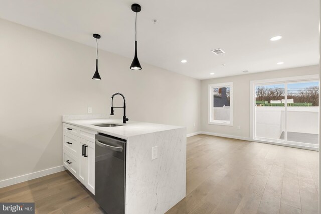 kitchen featuring sink, white cabinetry, hanging light fixtures, light stone counters, and stainless steel dishwasher