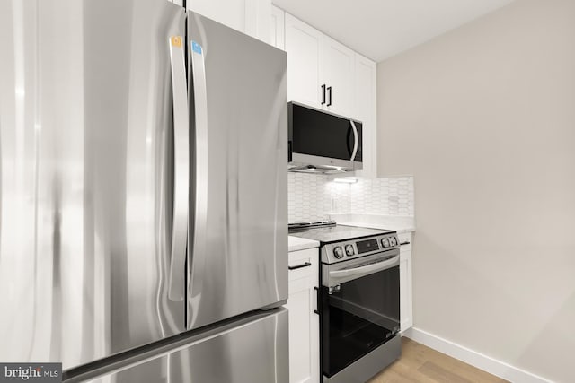 kitchen featuring white cabinetry, tasteful backsplash, stainless steel appliances, and light hardwood / wood-style flooring