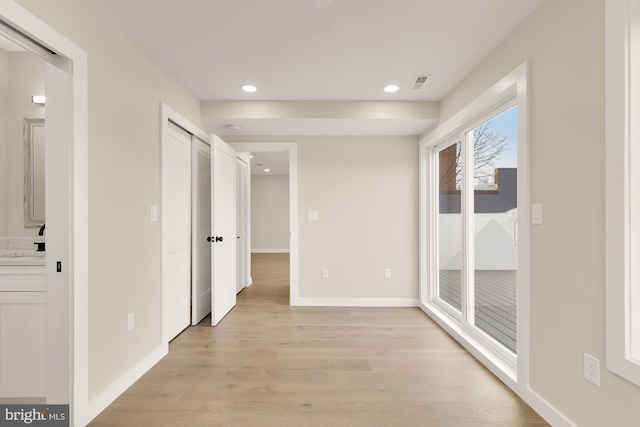 hallway featuring sink and light hardwood / wood-style flooring