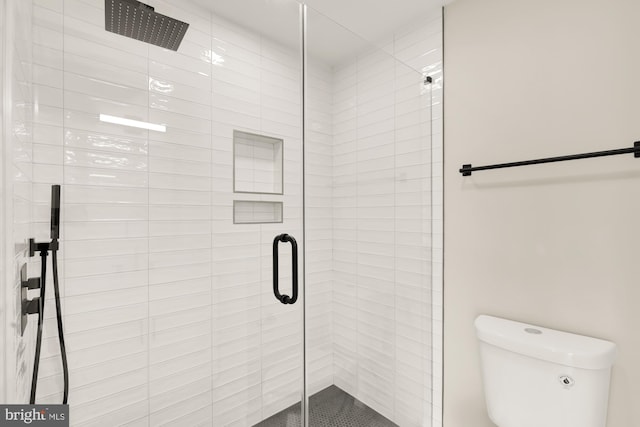 bathroom with an enclosed shower and toilet