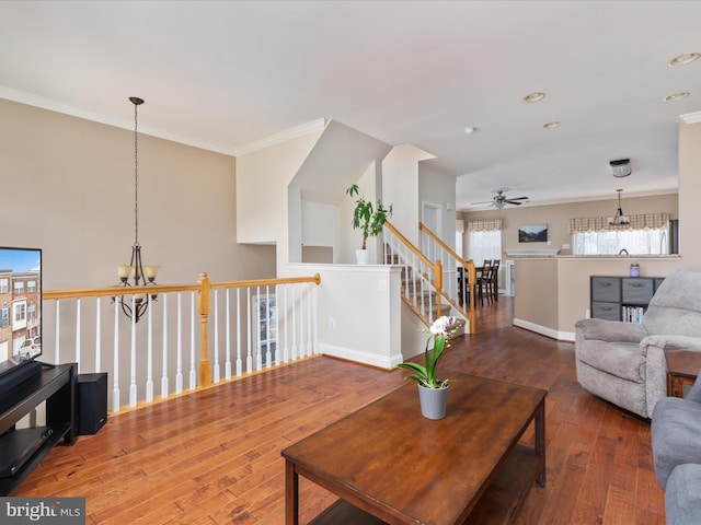 living room featuring hardwood / wood-style floors, ornamental molding, and a chandelier