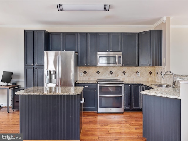 kitchen with light stone counters, sink, light hardwood / wood-style flooring, and appliances with stainless steel finishes