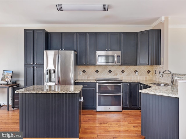 kitchen featuring sink, light stone countertops, light hardwood / wood-style floors, and appliances with stainless steel finishes