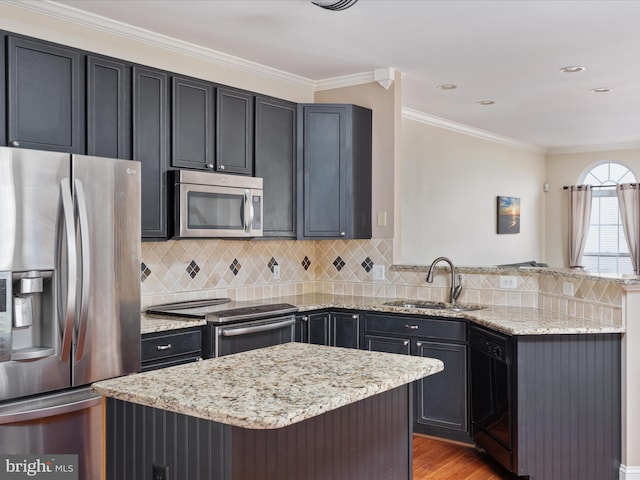 kitchen with sink, ornamental molding, light stone countertops, and appliances with stainless steel finishes