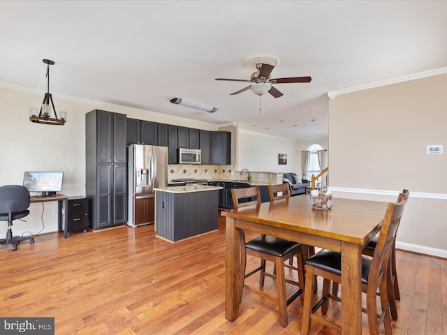 dining room with ornamental molding, sink, ceiling fan, and light hardwood / wood-style flooring