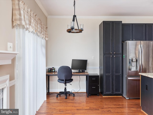 home office with an inviting chandelier, light hardwood / wood-style flooring, and ornamental molding