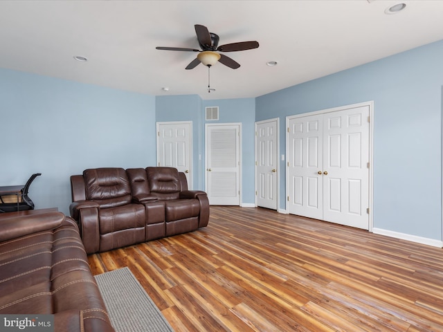 living room featuring hardwood / wood-style floors and ceiling fan