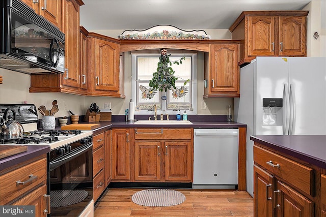 kitchen featuring sink, white appliances, and light hardwood / wood-style floors