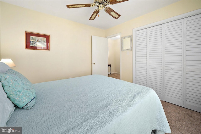 carpeted bedroom with ceiling fan and a closet