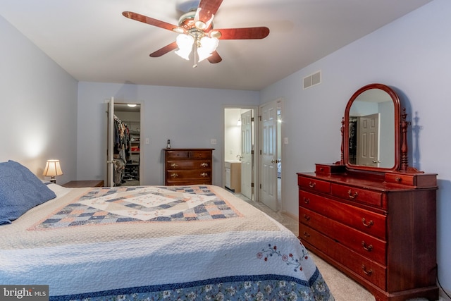 bedroom with ensuite bath, ceiling fan, light carpet, a spacious closet, and a closet