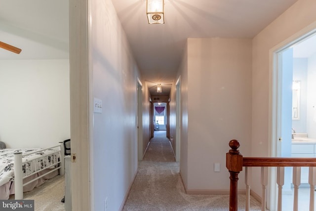 hallway with sink and light carpet