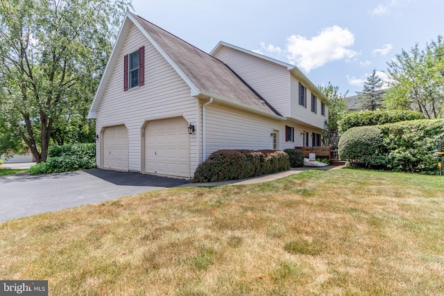 view of home's exterior featuring a garage and a yard