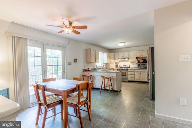 dining space featuring ceiling fan and sink