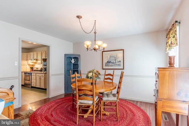 dining space featuring a notable chandelier and light wood-type flooring