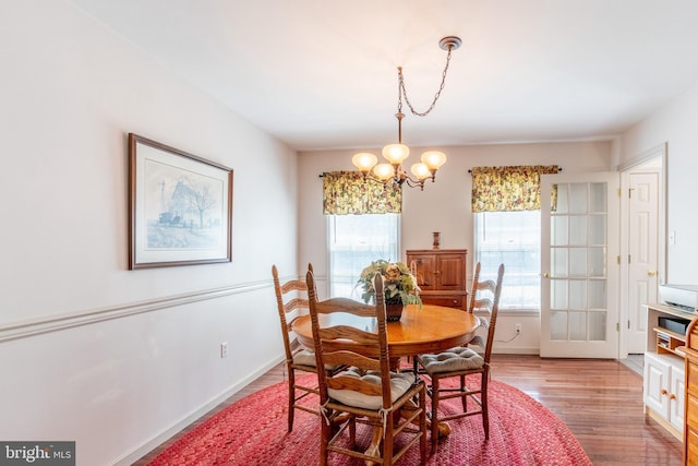 dining space featuring a notable chandelier, light hardwood / wood-style floors, and a healthy amount of sunlight