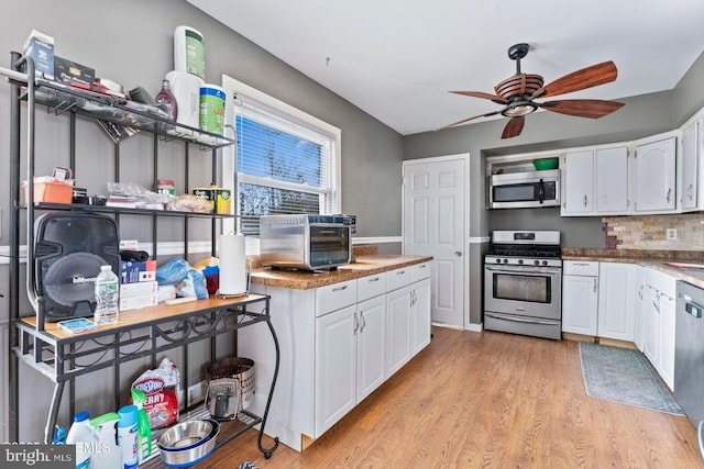 kitchen featuring ceiling fan, stainless steel appliances, tasteful backsplash, light hardwood / wood-style floors, and white cabinets