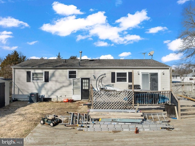 rear view of property with a wooden deck and central air condition unit