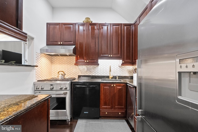 kitchen featuring wall chimney range hood, sink, appliances with stainless steel finishes, tasteful backsplash, and dark stone counters