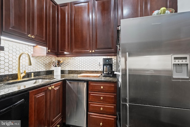 kitchen featuring sink, dishwasher, dark stone countertops, stainless steel refrigerator with ice dispenser, and tasteful backsplash