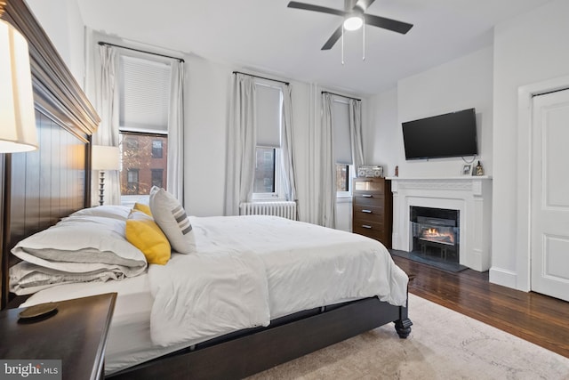 bedroom featuring radiator, dark wood-type flooring, and ceiling fan