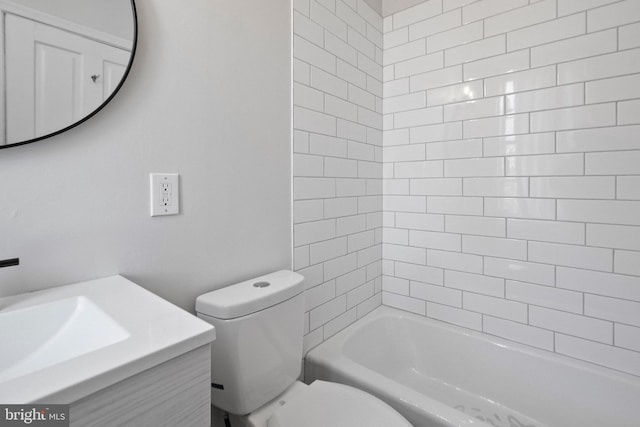 full bathroom with tiled shower / bath, vanity, and toilet