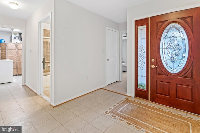 foyer with light tile patterned flooring and washer / dryer