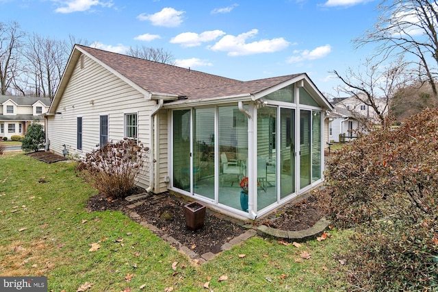 view of home's exterior featuring a yard and a sunroom