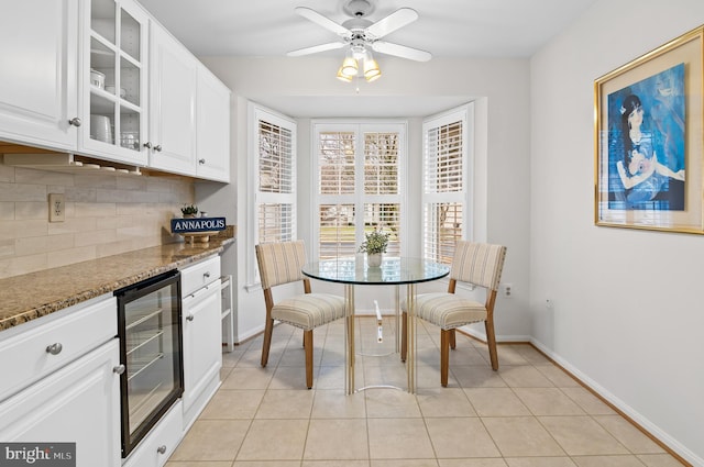 dining room with light tile patterned floors, beverage cooler, and ceiling fan