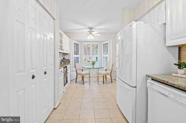 kitchen with white cabinetry, dishwasher, light tile patterned flooring, and light stone countertops